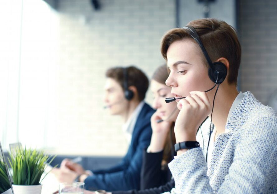 Attractive positive young businesspeople and colleagues in a call center office