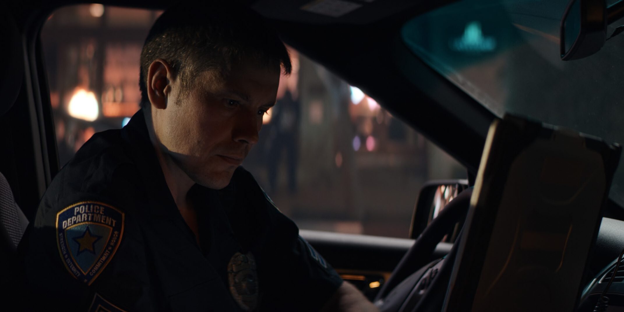 Police officer checking records on a laptop inside a car